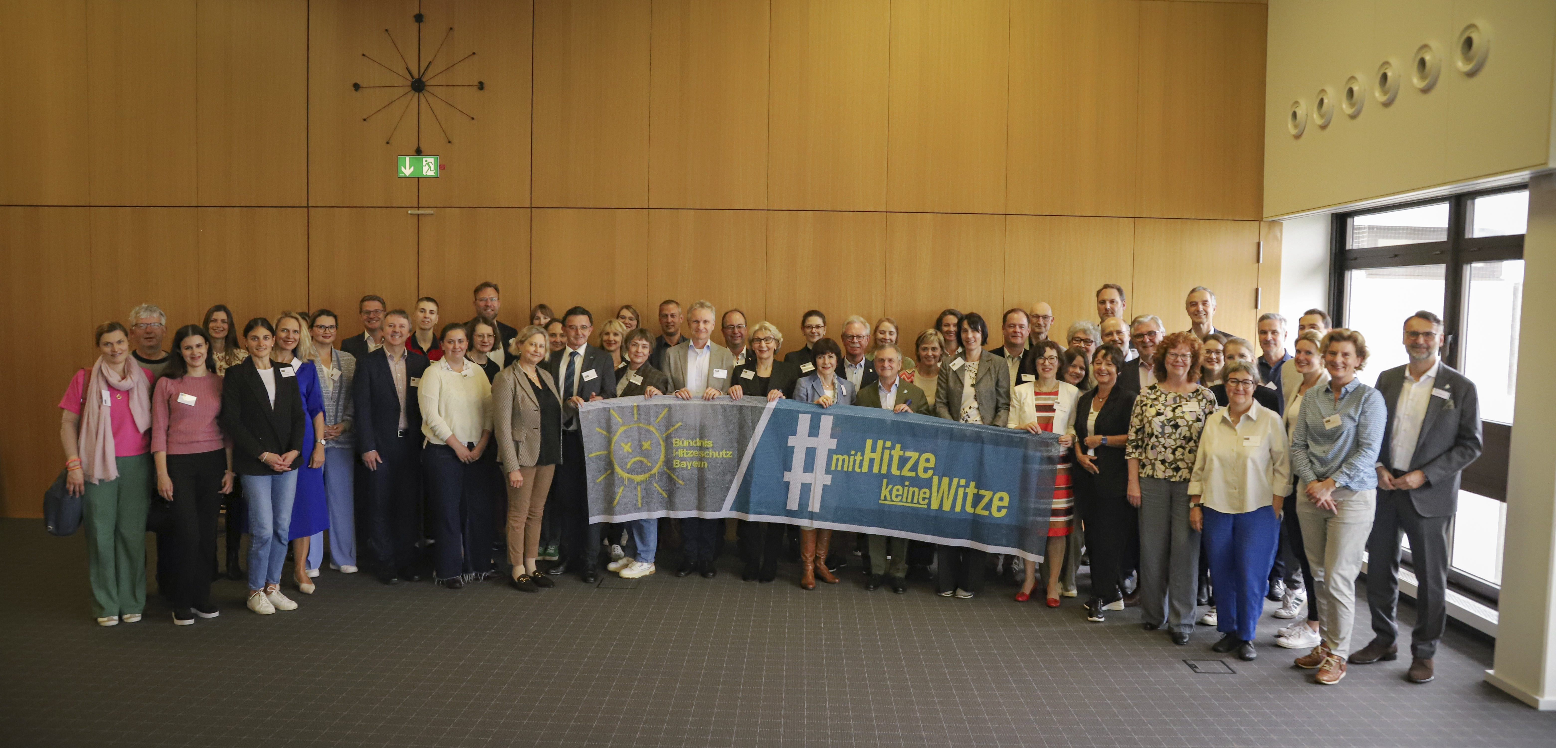 Zu sehen sind die Teilnehmenden des Hitzeaktionstags. Sie halten ein Banner mit der Aufschrift: Mit Hitze keine Witze